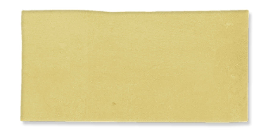 A single, rectangular sheet of uncooked yellow lasagna pasta against a white background.