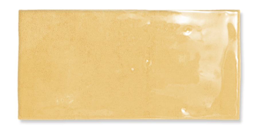 A glossy rectangular yellow ceramic tile with a smooth, reflective surface and slightly uneven edges.