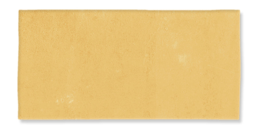 A rectangular sheet of uncooked pasta dough with a smooth, slightly uneven yellow surface, photographed against a white background.