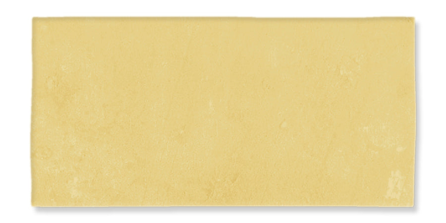 A rectangular sheet of light-yellow pasta dough, smooth and flat, against a white background.