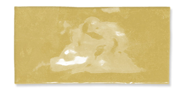 A rectangular block of light yellow processed cheese with a glossy surface, showing some subtle, irregular light and shadow patterns.