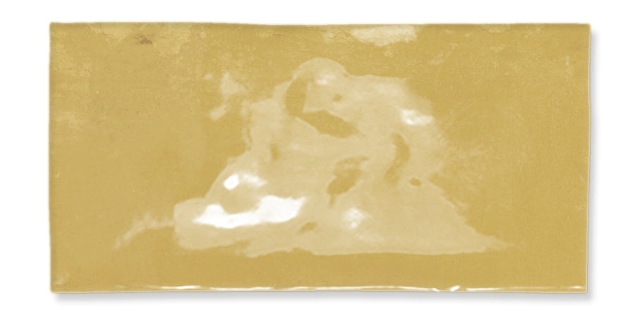 A rectangular, yellowish surface with a faint, abstract, white shape in the center that resembles a blurry or partially visible figure or face. The background is uniform and slightly textured.