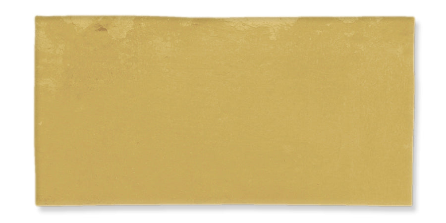 A rectangular, flat, golden yellow tile with a smooth, slightly glossy surface and subtle texture variations.