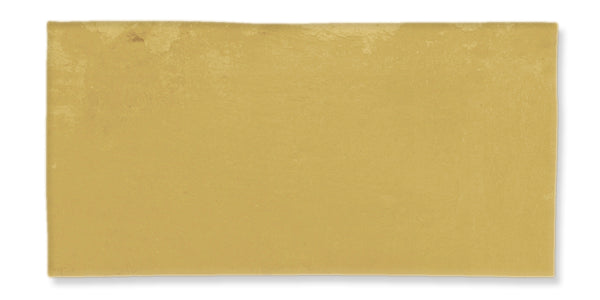 A rectangular, flat, golden yellow tile with a smooth, slightly glossy surface and subtle texture variations.
