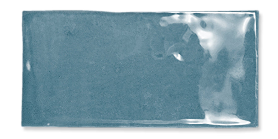 A rectangular, glossy, blue ceramic tile with a slightly uneven surface and subtle color variations, set against a white background.