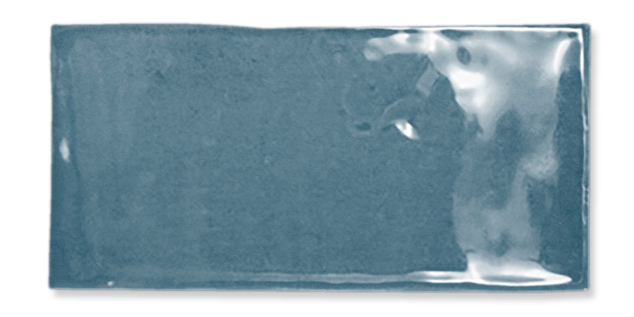 A rectangular, glossy blue ceramic tile with a smooth surface and slight reflections, photographed against a white background.