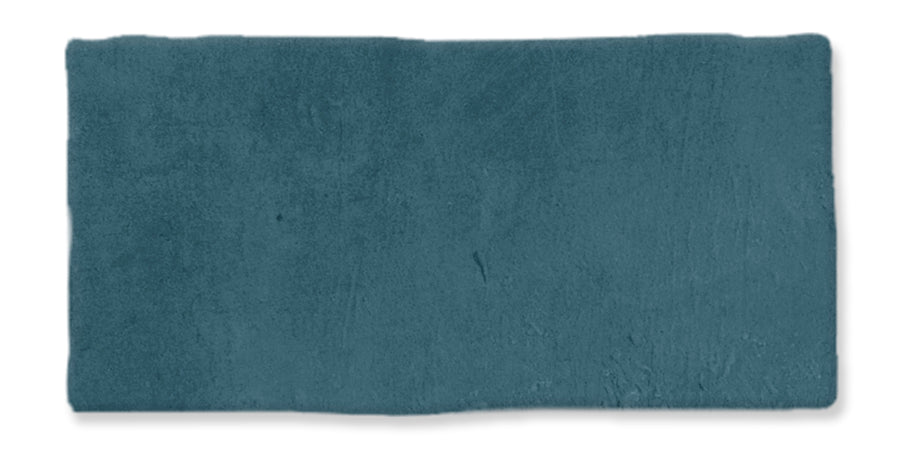 A rectangular swatch of teal blue textured material, resembling clay or paint, with uneven edges and subtle surface variations.