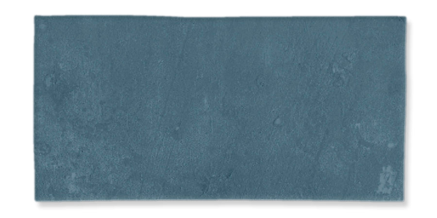 A rectangular, blue-gray tile with a slightly textured, matte surface is displayed against a white background.