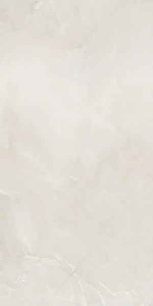 A smooth, light beige marble surface with subtle white and cream veining, creating a soft, cloudy pattern across the stone.