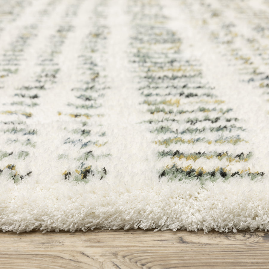Close-up of a plush white area rug with subtle green, yellow, and black patterned lines, shown on a light-colored wooden floor.