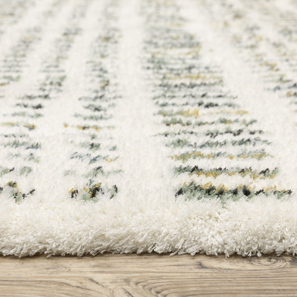 Close-up of a plush white area rug with subtle green, yellow, and black patterned lines, shown on a light-colored wooden floor.