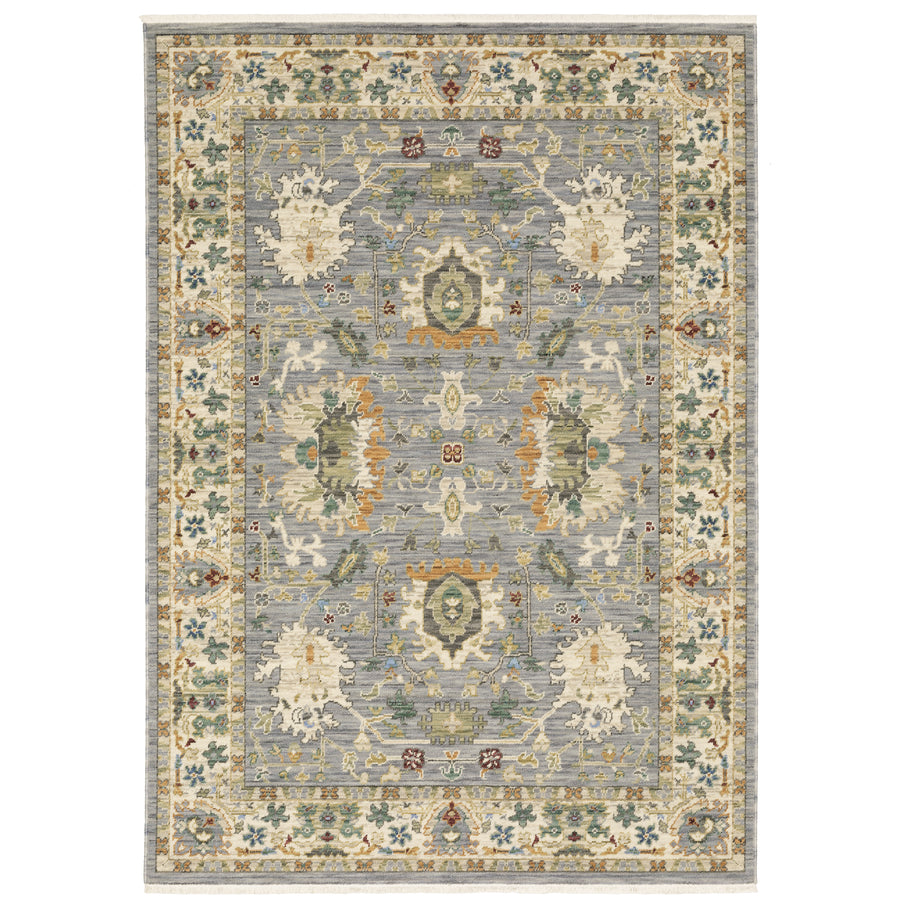 The Lucca 2063L Area Rug is a rectangular area rug featuring traditional floral and geometric patterns in muted blue, cream, green, and gold, with an ornate border and a symmetrical central design.
