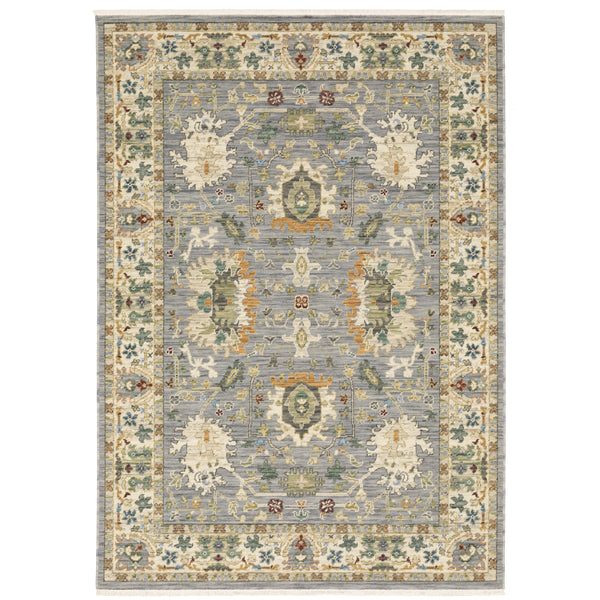 The Lucca 2063L Area Rug is a rectangular area rug featuring traditional floral and geometric patterns in muted blue, cream, green, and gold, with an ornate border and a symmetrical central design.