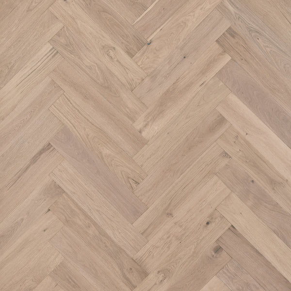 Main Street Herringbone White Oak Hardwood flooring features light brown planks in a classic herringbone pattern, highlighting visible wood grain and texture for an elegant, luxurious look.