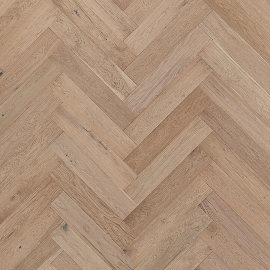 Main Street Herringbone White Oak Hardwood features light brown luxury planks with a herringbone pattern, showcasing the natural wood grain and subtle knots of elegant white oak.