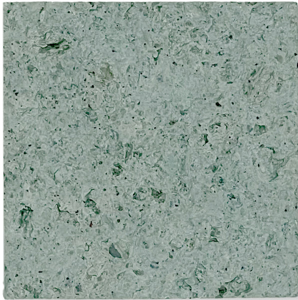 A close-up of Sukabumi Select 6x6 Honed Natural Stone reveals a textured gray-green surface with irregular patterns and dark and light flecks, mimicking premium material or natural stone.