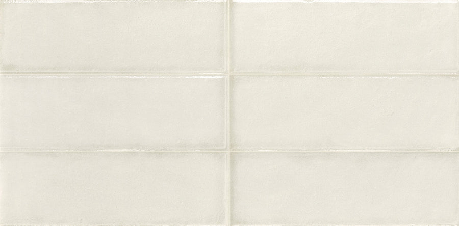 A close-up of Cadence 12" x 24" Framed Tile in Polar shows its smooth, light beige surface with subtle sheen and visible grout forming a grid, creating a clean, modern look.