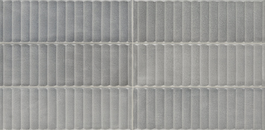 Close-up of six Cadence 12" x 24" Fluted Tiles in Polar, arranged in a 2x3 grid with horizontal ridges and white grout lines—perfect for a modern bathroom wall.