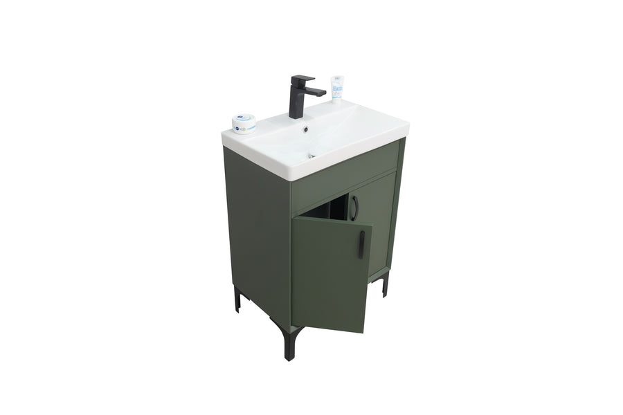 A modern green bathroom vanity with black legs, a white sink, a black faucet, two small containers on the countertop, and one cabinet door partially open. The background is plain white.