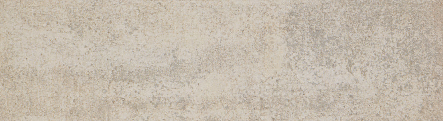 A close-up of the Hans.A 2.5" x 9" Subway Tile in Medium shows a textured surface with subtle color and pattern variations, echoing a weathered accent wall for a timeless effect.