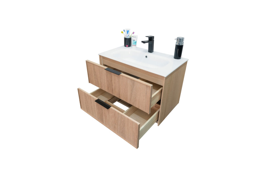 A wooden bathroom vanity with a white sink, two partially open drawers, toothbrushes, a toothpaste tube, a soap dispenser, and a black faucet on top. The background is plain white.