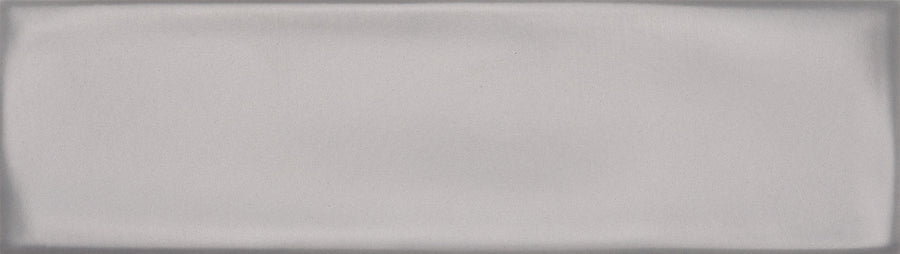 The Maestro 3" x 10" Subway Tile in Wolfgang Matte features a rectangular, smooth light gray surface with soft edge shadows for a modern, subtly padded look similar to contemporary bathroom wall tiles.