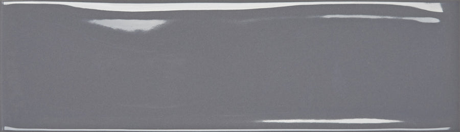 The Maestro 3" x 10" Subway Tile in Amadeus Glossy features a sleek, glossy gray finish and slightly beveled edges—ideal for modern kitchen backsplashes or bathroom walls.