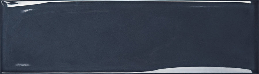 The Maestro 3" x 10" Subway Tile in Beethoven Glossy features a rectangular, dark blue ceramic design with beveled edges and white highlights—an ideal choice for a stylish bathroom wall or modern kitchen backsplash.