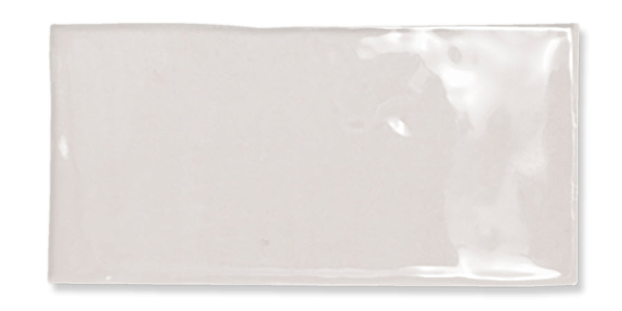 A rectangular, glossy, off-white ceramic tile with slightly uneven edges and a smooth, shiny surface.