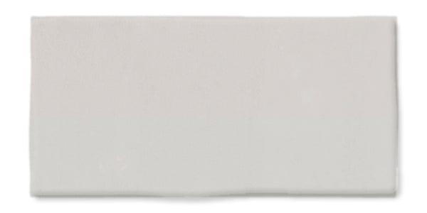 A rectangular, plain white ceramic tile with a smooth, glossy surface and slightly uneven edges displayed against a white background.