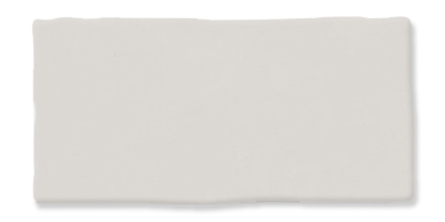 A rectangular off-white ceramic tile with slightly uneven edges and a smooth, matte surface.
