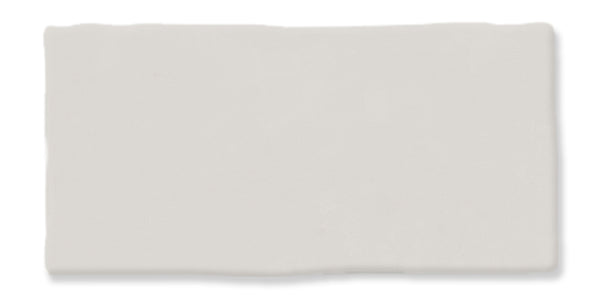 A rectangular off-white ceramic tile with slightly uneven edges and a smooth, matte surface.