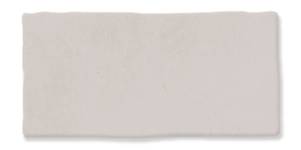 A rectangular, off-white ceramic tile with slightly uneven edges and a matte finish.