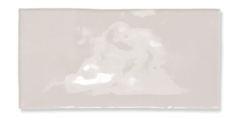 A rectangular, glossy, off-white ceramic tile with a slightly uneven surface and subtle reflections.
