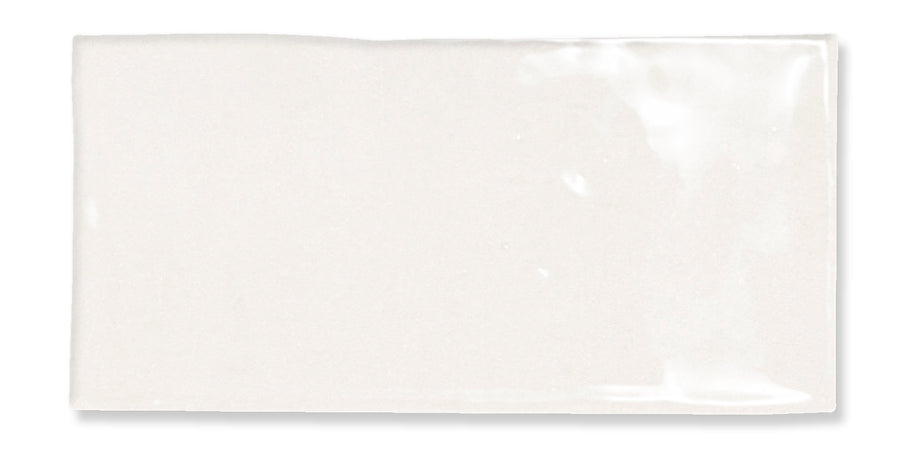 A rectangular, glossy white tile with a smooth surface and slightly uneven edges, reflecting light on its top right corner.