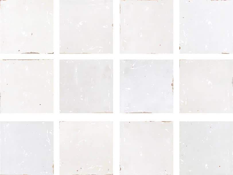 A grid of twelve white, slightly weathered square tiles with subtle scratches and worn edges, separated by thin white grout lines.