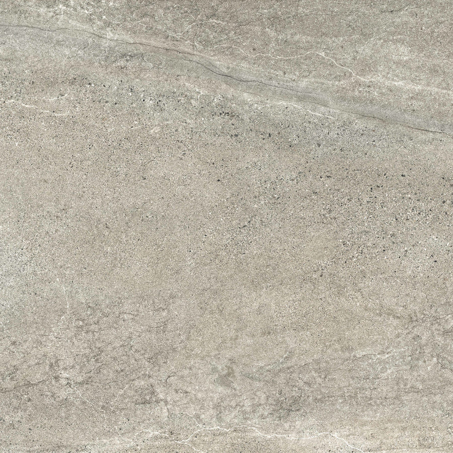 A close-up of the Santorini 24x24 Porcelain Tile shows its textured gray stone-effect surface with subtle white veining and speckled patterns, capturing the tactile elegance of natural marble or granite.