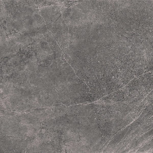 A close-up of Santorini 24x24 Porcelain Tile reveals a dark gray stone-effect surface with subtle white veins, featuring tactile elegance and a slightly rough, speckled texture.