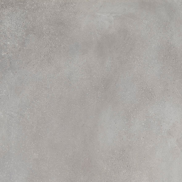 A close-up of Portland 24x24 Porcelain Tile reveals a light gray textured concrete look with subtle color variations and scattered speckles, highlighting authentic surface imperfections.