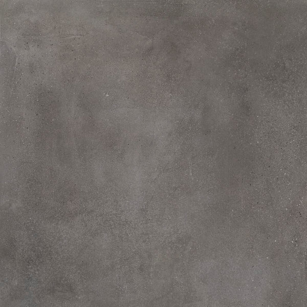 The Portland 24x24 Porcelain Tile features a textured dark gray finish with subtle color variations, small speckles, and slight surface imperfections for a weathered, industrial look inspired by concrete.