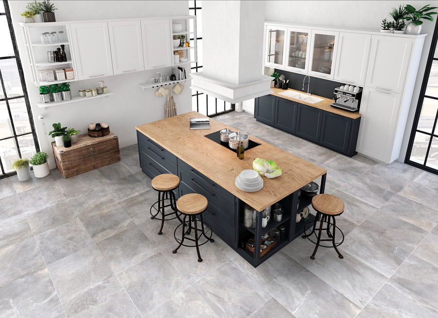 Modern kitchen with a large island featuring Gemini 24x48 Rectified Porcelain Tile countertop, three bar stools, open shelving with dishes, white and black cabinets, and big windows—ideal for residential or light commercial spaces.