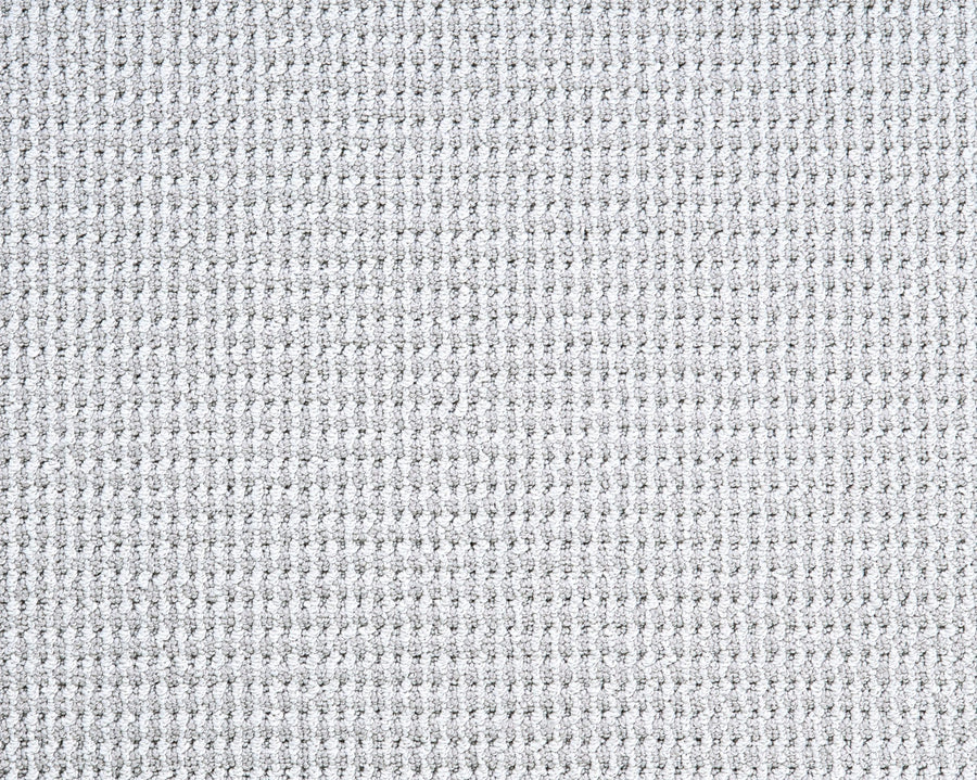 Close-up of Bandala Jazzed Berber Carpet in light gray, featuring a waffle-like grid pattern with small, evenly spaced squares that create a soft yet structured look, reminiscent of a sisal-inspired area rug.