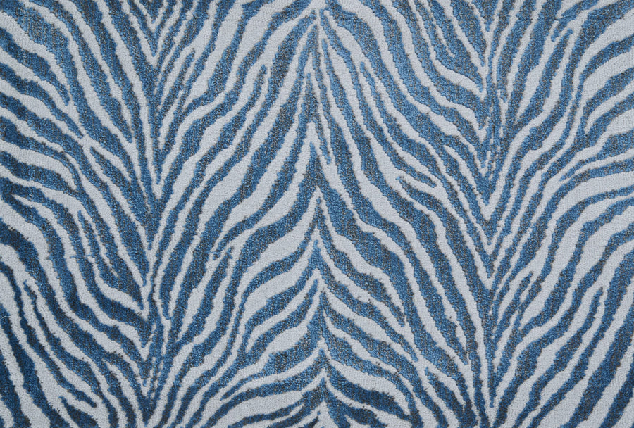 The Boteti On Trend Carpet features bold blue and white zebra stripes with wavy, organic lines, creating a symmetrical animal-inspired design ideal for contemporary décor.
