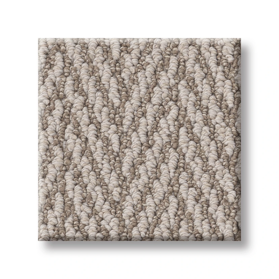 A square sample of Always Natural On Trend Carpet in light beige and taupe hues features a herringbone pattern with soft, tightly woven fibers. Shadows highlight the raised texture, showcasing this stylish premium carpet.