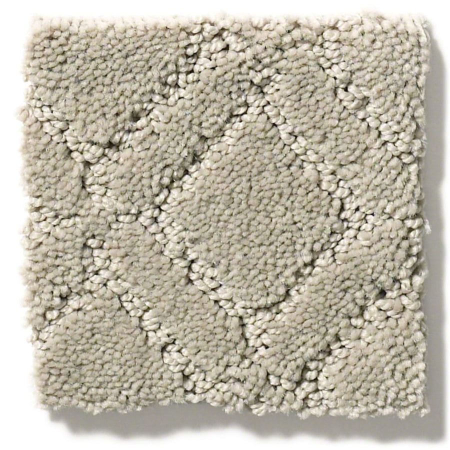 A square sample of Muse On Trend Carpet in light beige features a textured, raised diamond pattern. The neutral tones and slightly darker outlines enhance its soft, plush look and accentuate the diamond shapes.