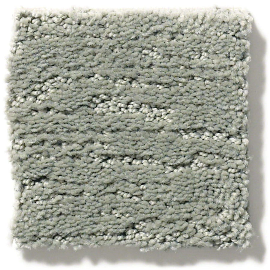 A square sample of Sketch On Trend Carpet in light gray features a plush, soft texture and subtle wavy pattern. Made from soil and stain-resistant nylon, its clean edges highlight nature-inspired neutral fibers.
