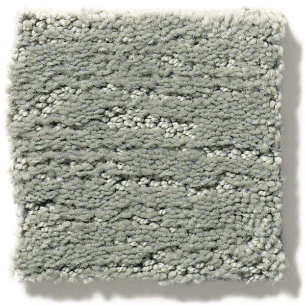 A square sample of Sketch On Trend Carpet in light gray features a plush, soft texture and subtle wavy pattern. Made from soil and stain-resistant nylon, its clean edges highlight nature-inspired neutral fibers.
