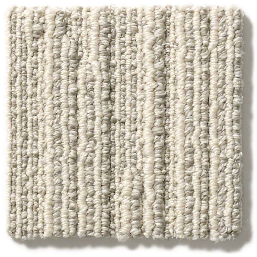 A close-up of the Chase Pet Friendly Carpet sample shows a light beige and gray patterned loop with soft linear texture, subtle vertical stripes, and tightly woven fibers—ideal for adding versatile neutrals to any space.