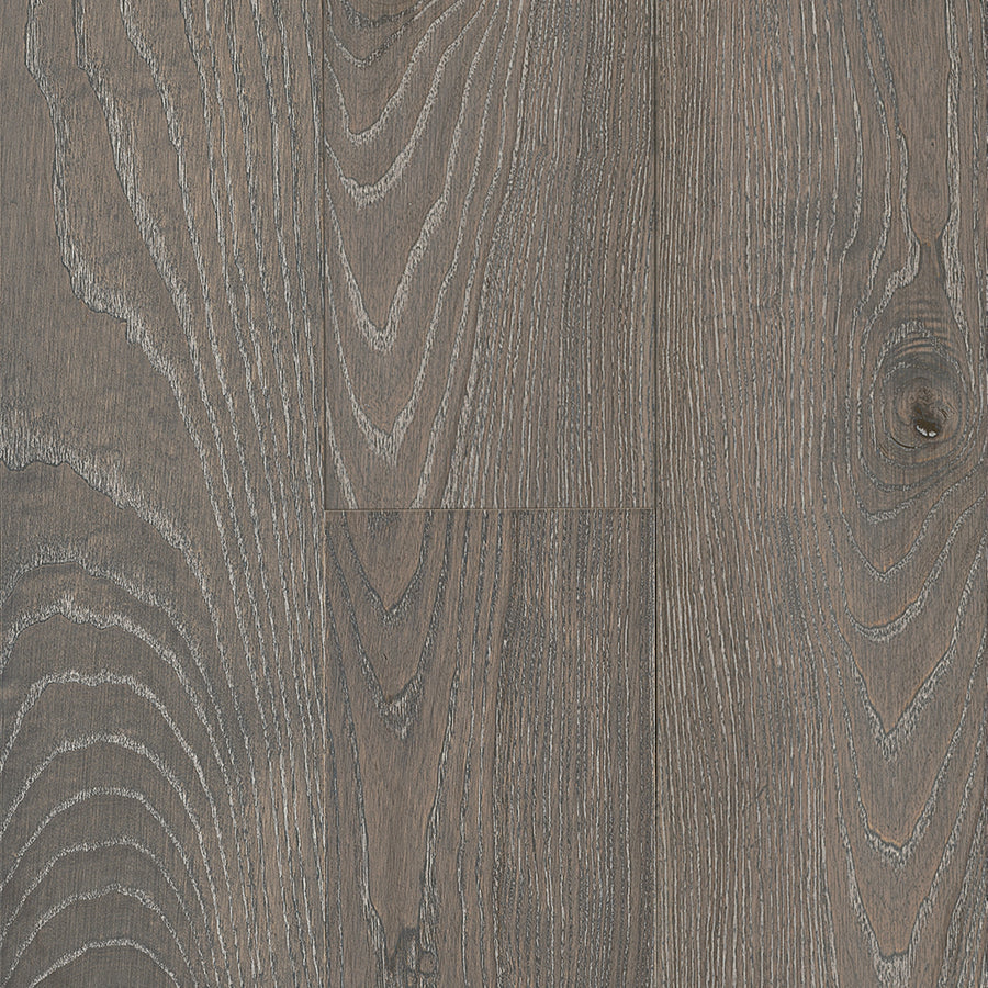 Close-up of Urban Forest 6.5" Ash Hardwood flooring, featuring a grayish-brown matte finish, visible wood grain, natural knots, and scratch-resistant surface that highlights its texture and unique variation.