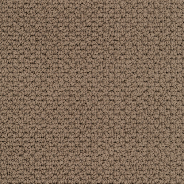 Close-up of Beachfront Berber Carpet, a textured brown performance carpet with tightly looped EnVision nylon fibers. Its uniform, slightly rough surface features neutral natural colors and subtle shading from the fiber arrangement.